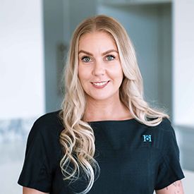 A woman in a blue shirt is standing in a field.