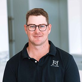 A man in a blue shirt is standing in a field.