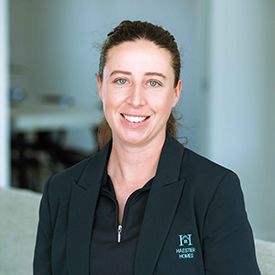 A woman in a blue shirt is standing in a field.