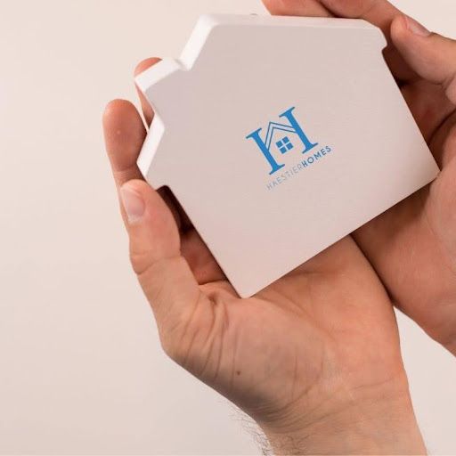 An empty kitchen with black appliances and white cabinets