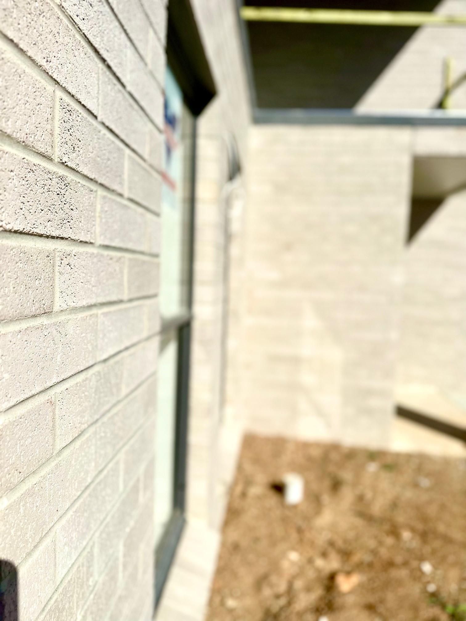 A close up of a white brick wall with a window.