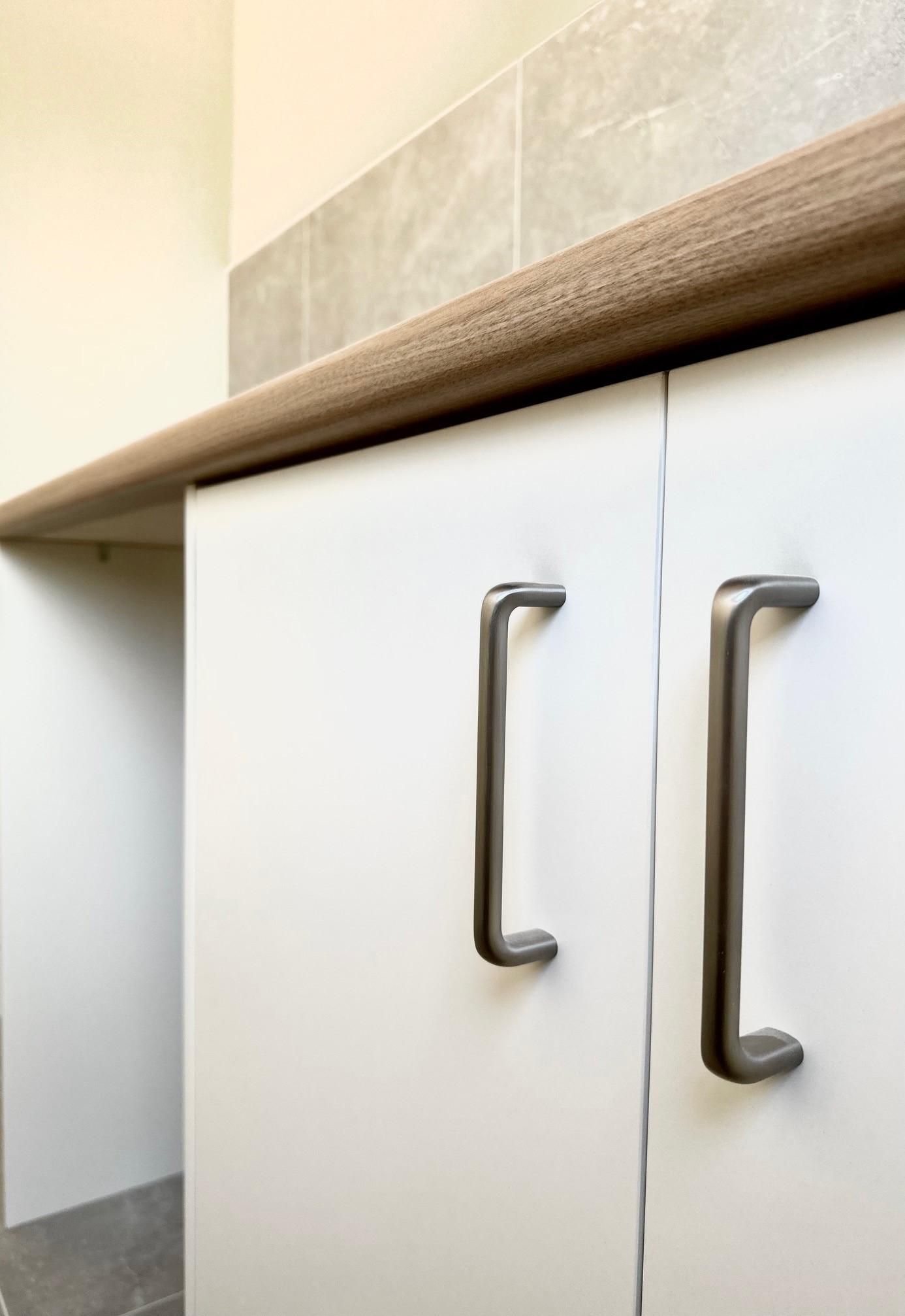 A close up of a kitchen cabinet with a wooden counter top.