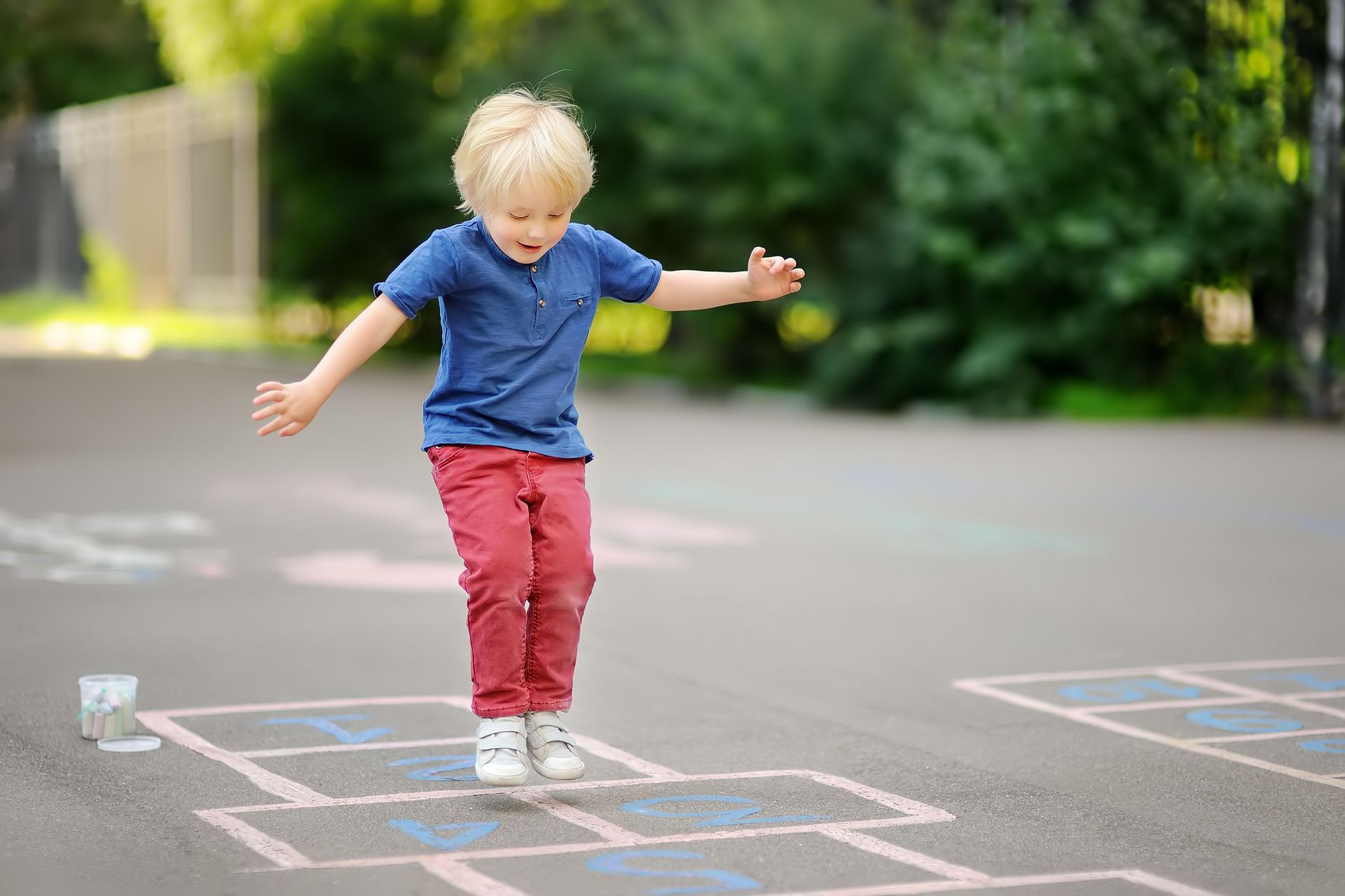 Child jumping on a hopscotch.