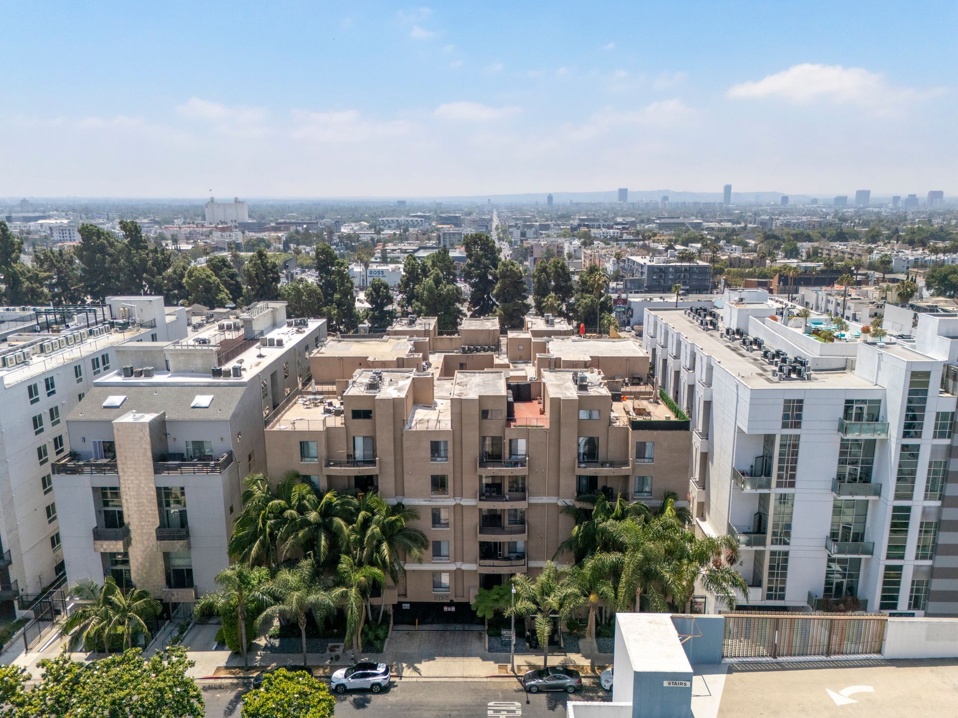 Cityscape with apartment buildings and palm trees under a clear blue sky