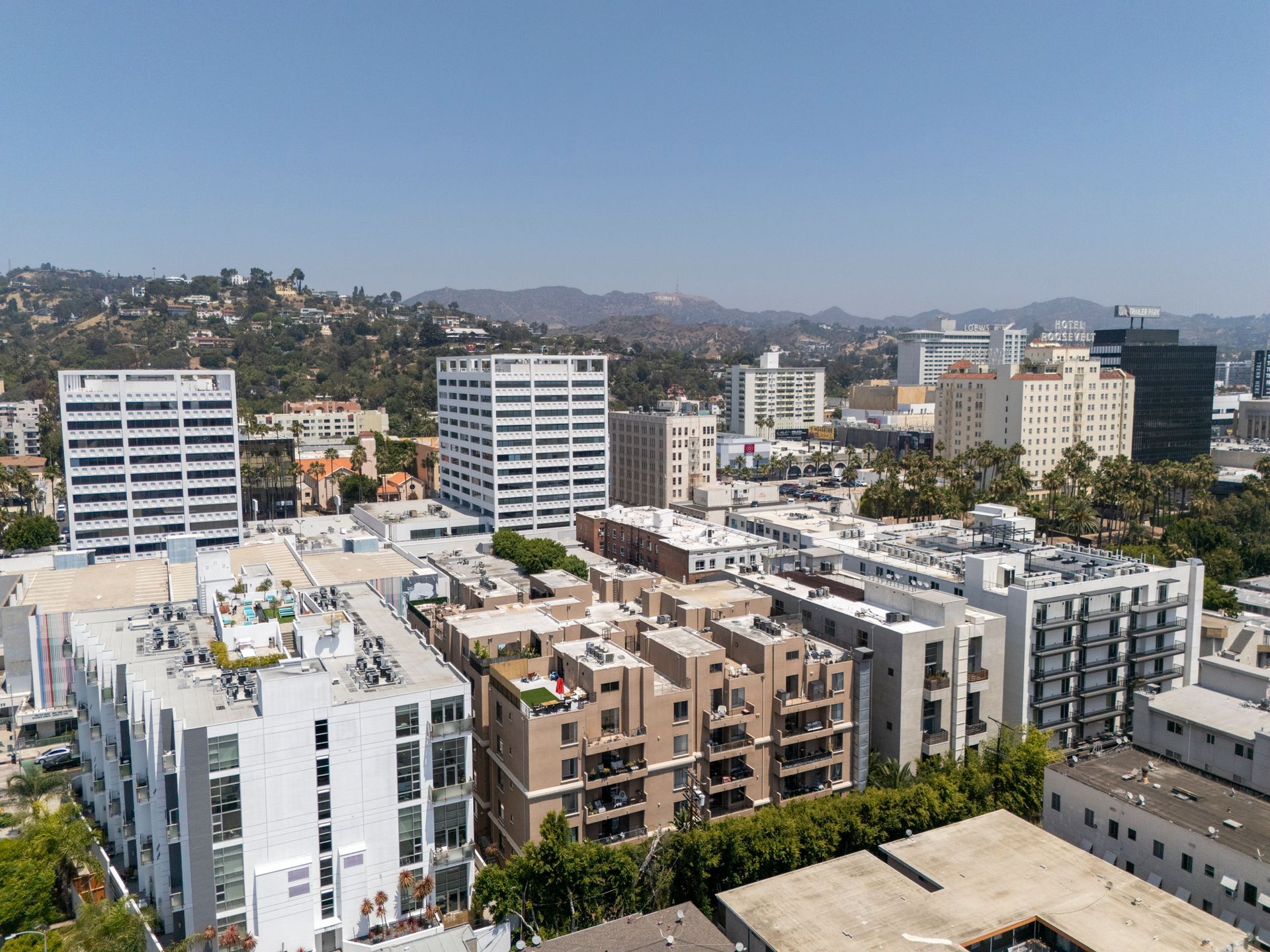 City skyline with mid-rise apartment buildings under a clear blue sky.