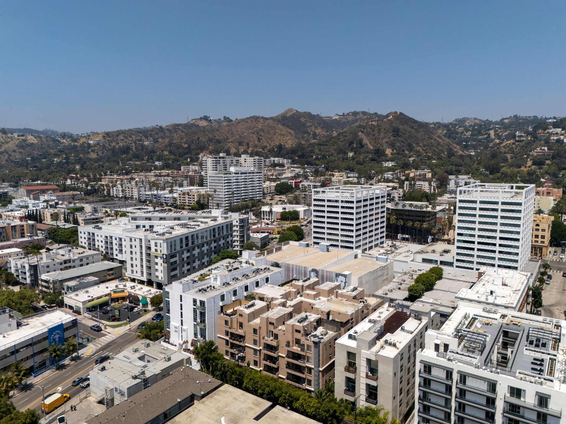 Aerial view of modern apartment buildings in a city with hills in the background