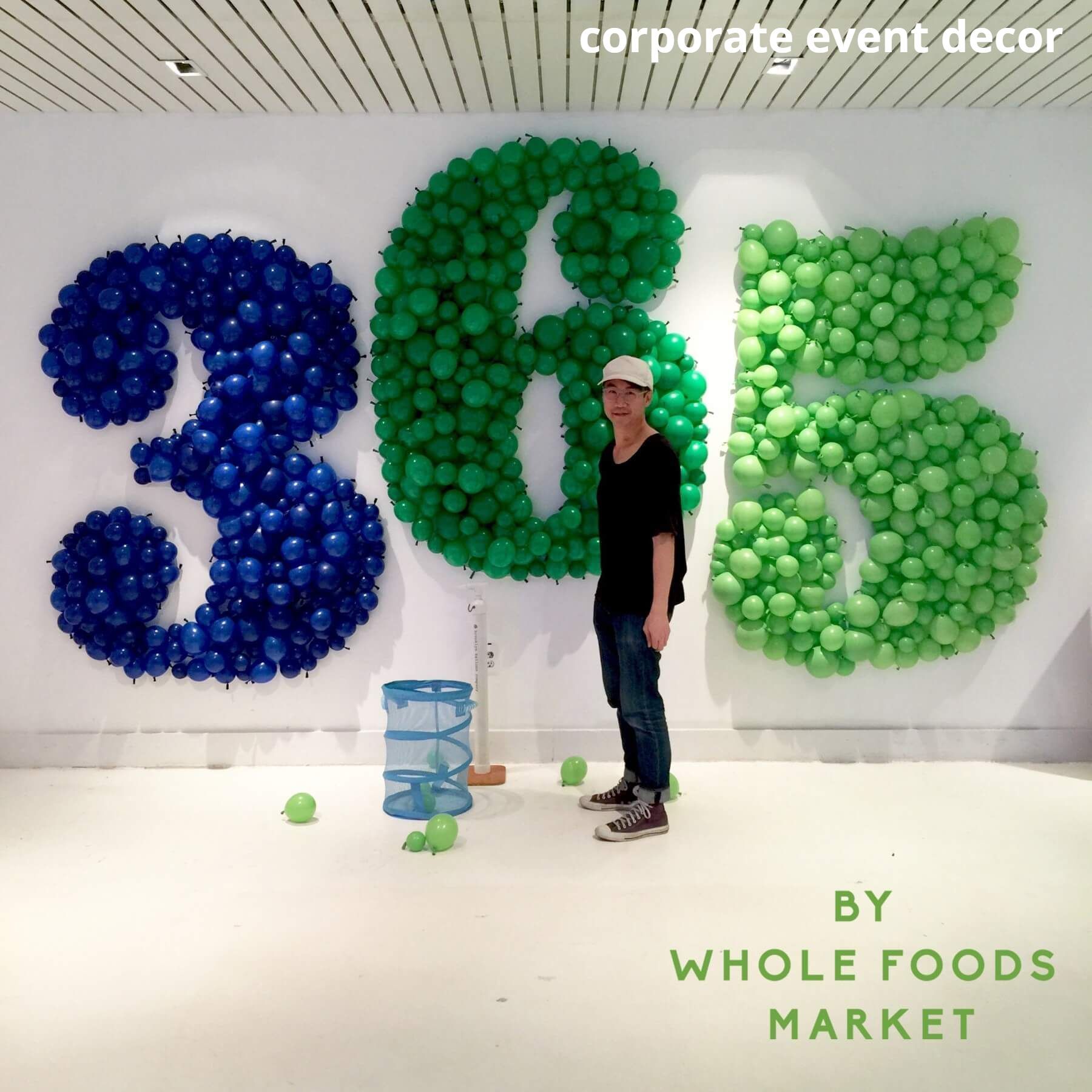 A man is standing in front of a sign that says 365 by whole foods market