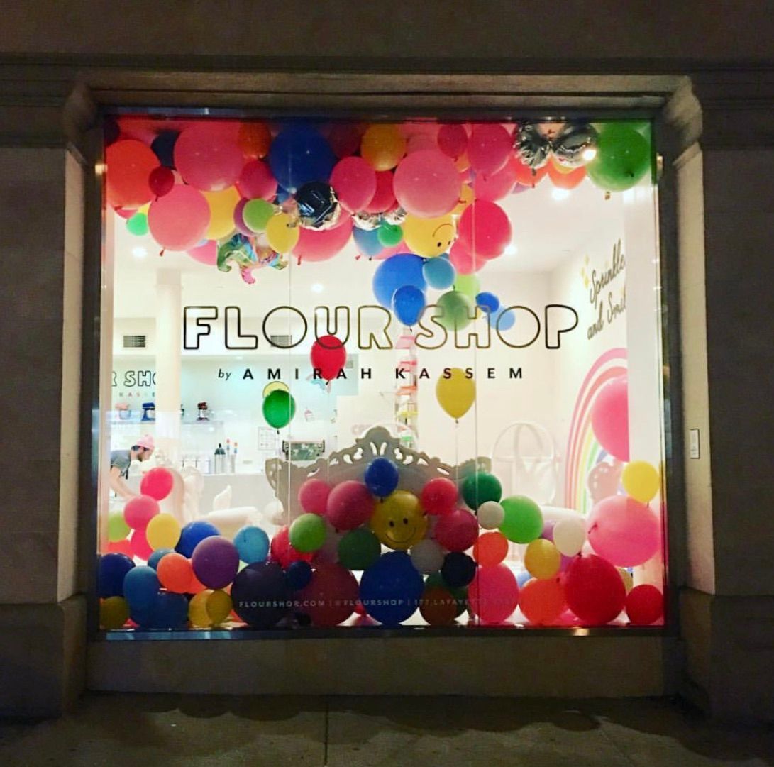 The flour shop window is decorated with colorful balloons