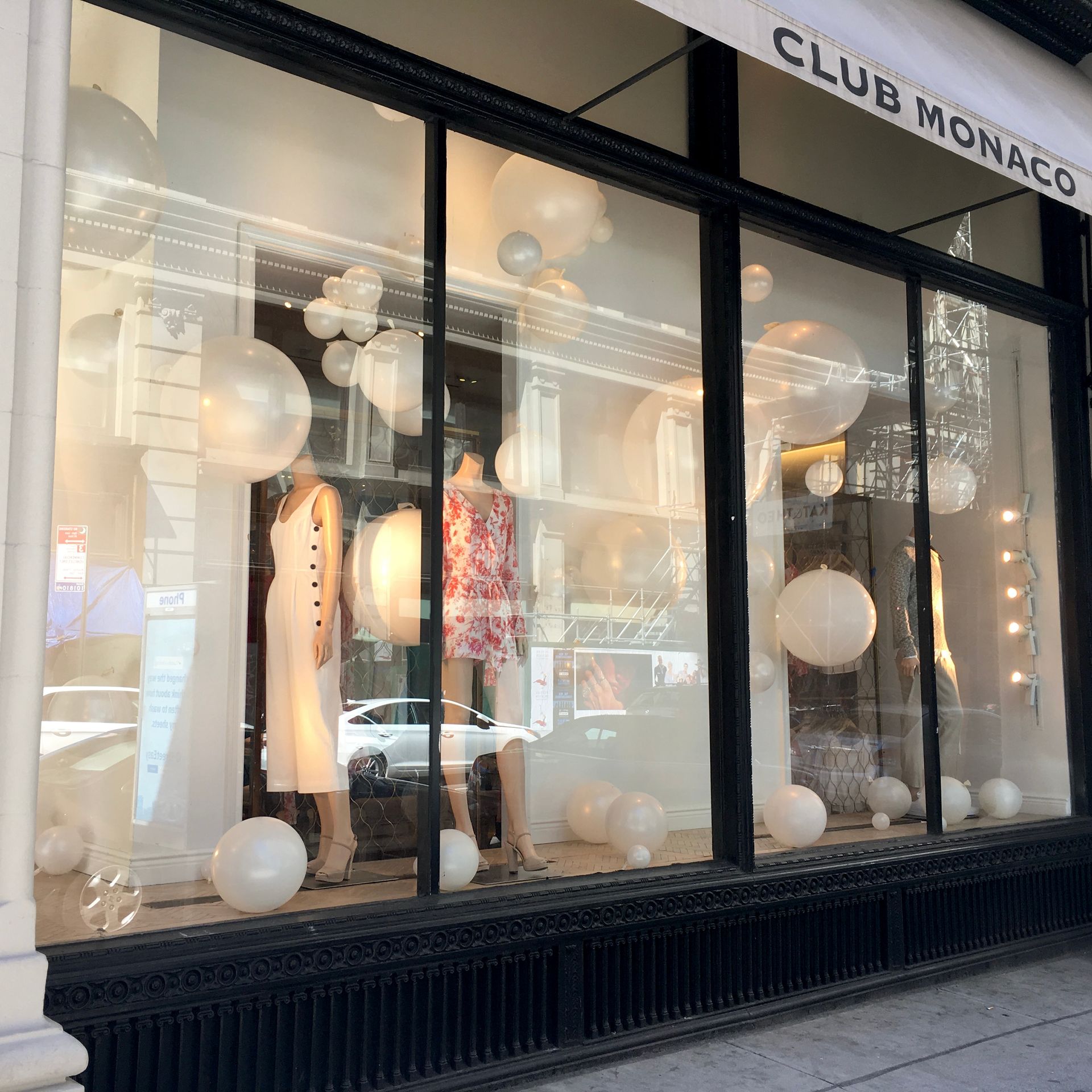 A club monaco store front with mannequins and balloons