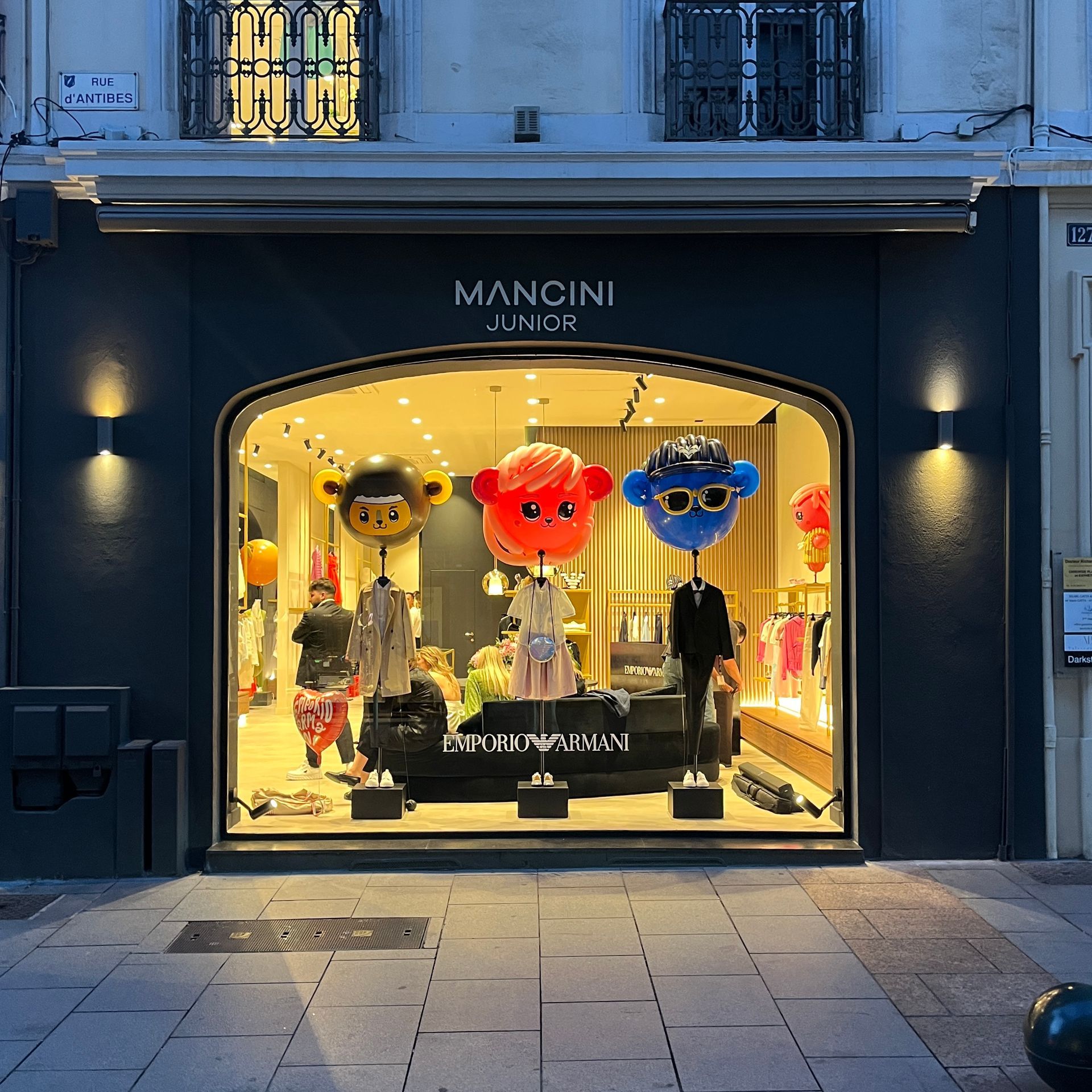 The front of a mancini junior store with balloons in the window