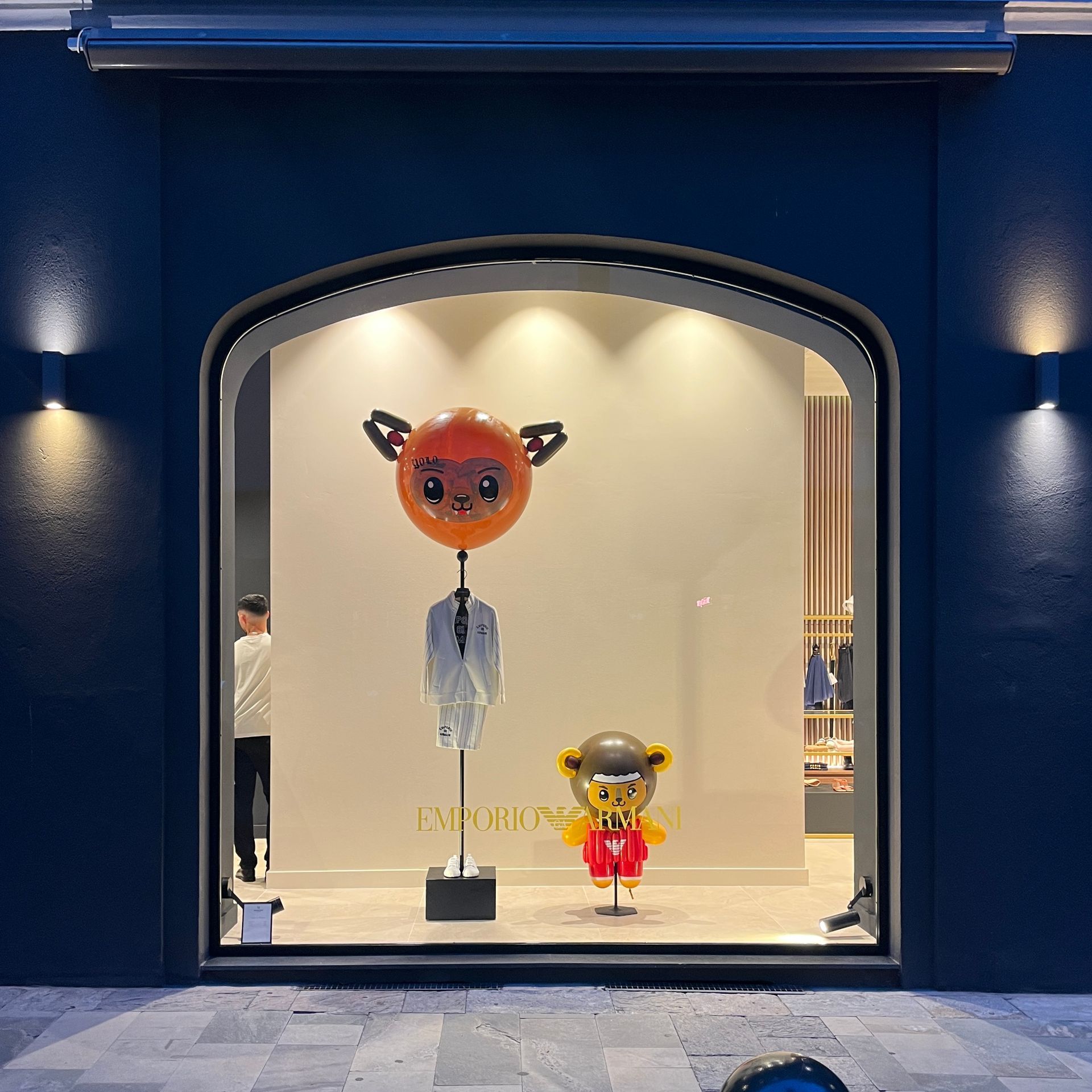 A store front with a display of a teddy bear and a pumpkin