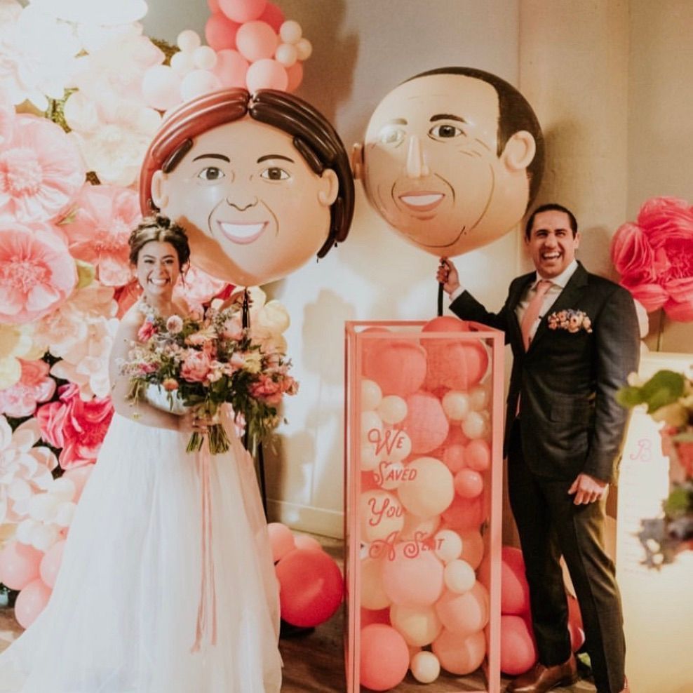 A bride and groom standing next to balloons that say we love you