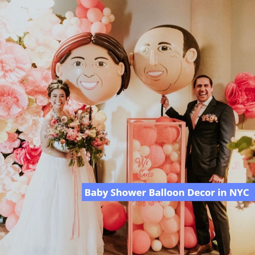 A bride and groom are standing next to a box of pink balloons