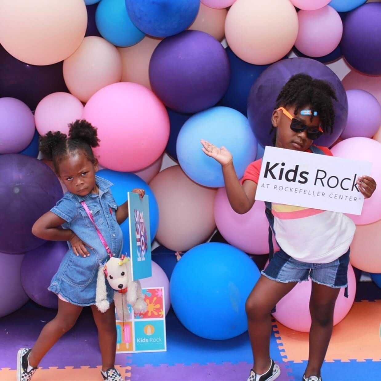 Two young girls holding a sign that says kids rock