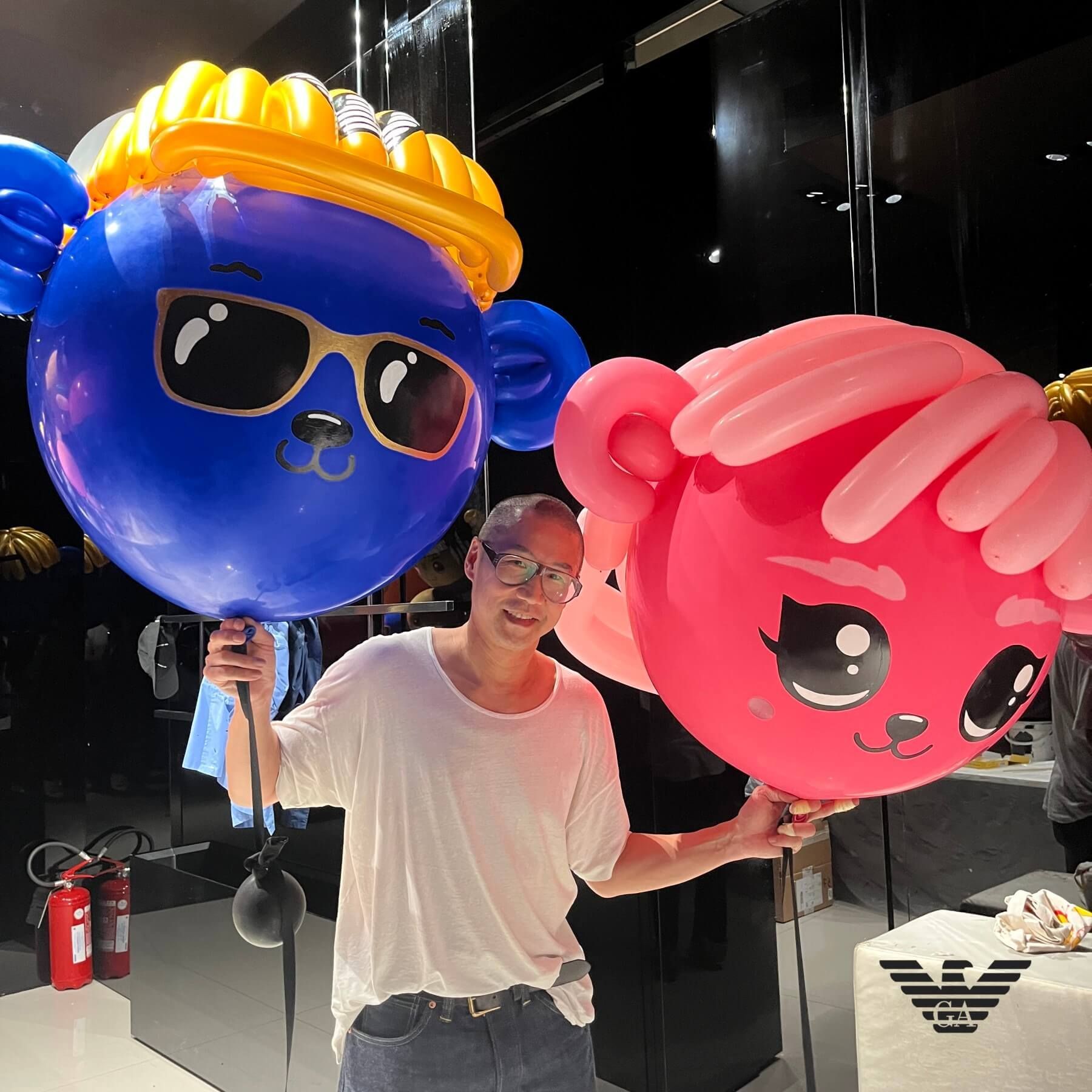 A man holding a blue balloon with a face on it