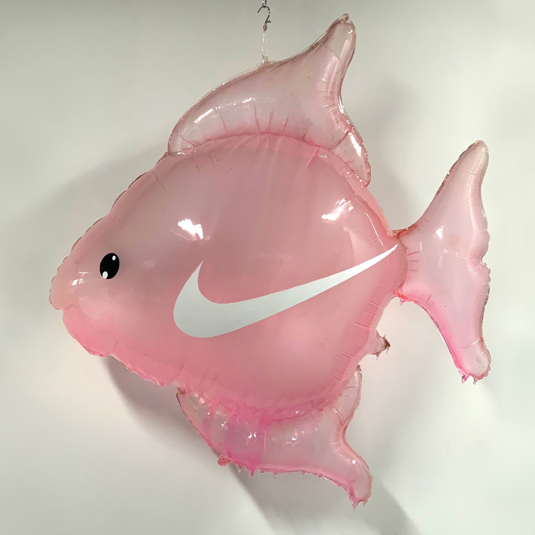 A pink balloon with a white nike logo on it
