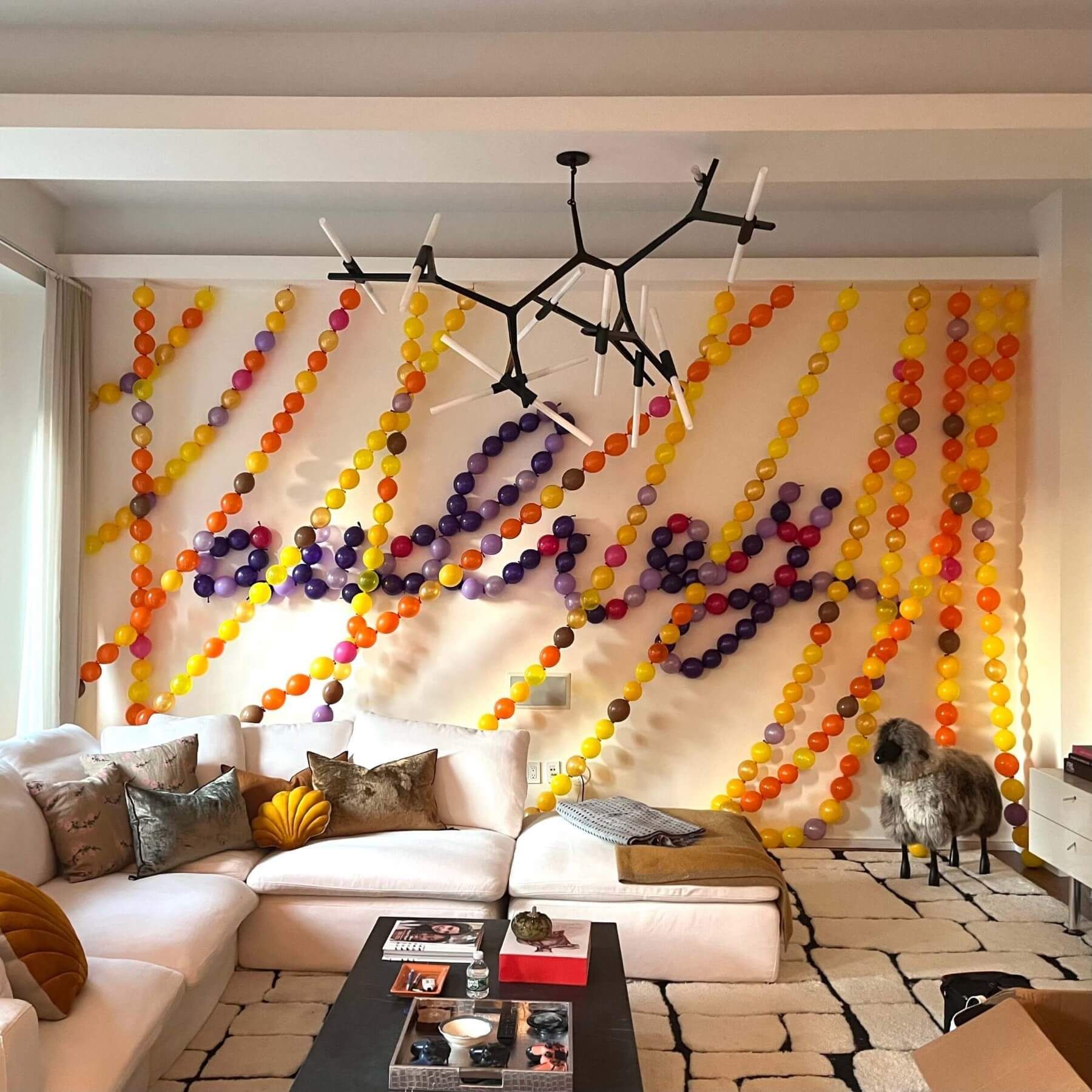 Living room with a white sectional sofa, colorful garland wall decor spelling 