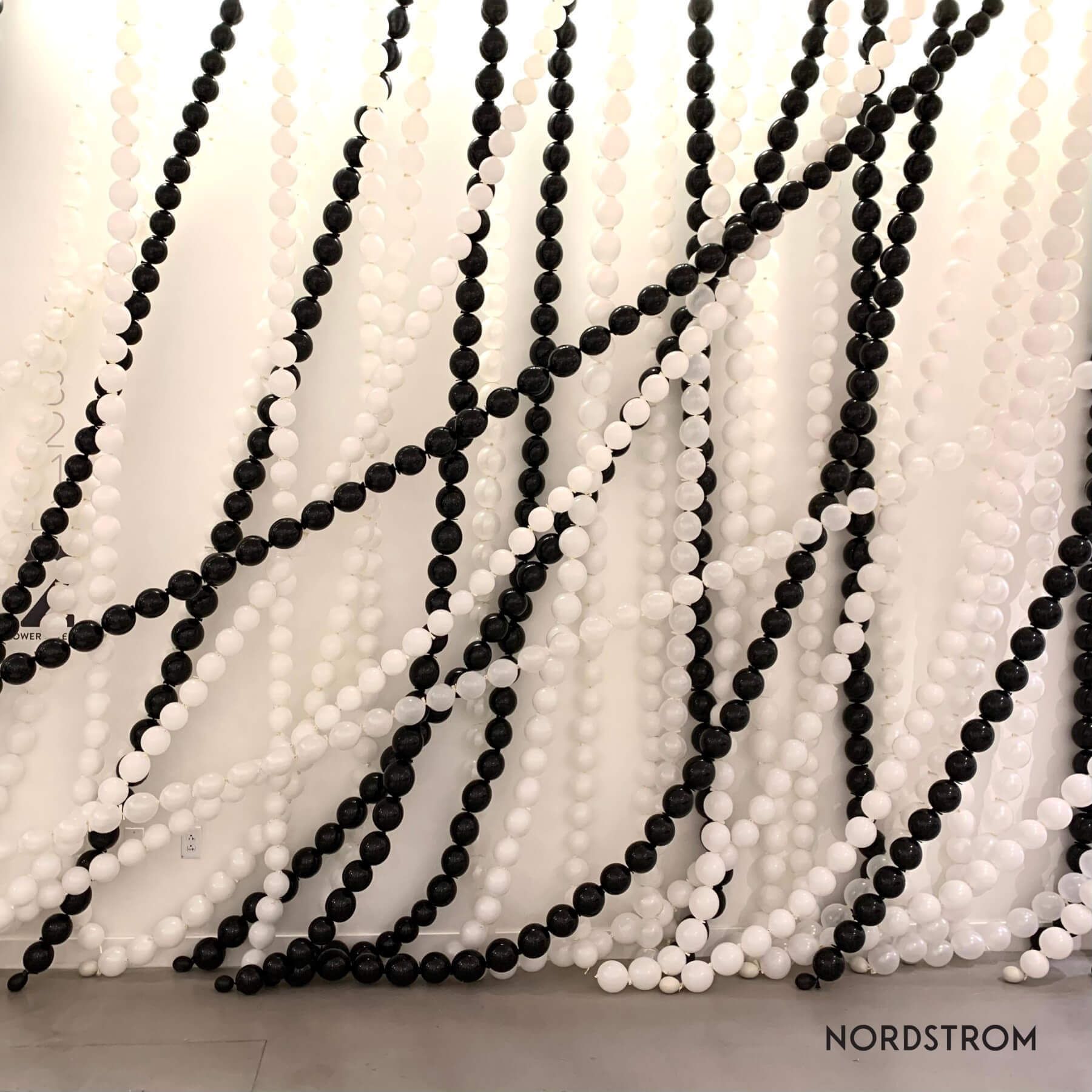 Black and white beaded strands draped against a white background. 