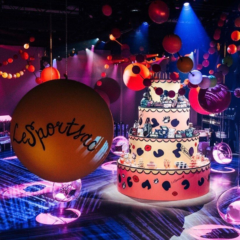 Party scene: large decorated cake, balloons, and 
