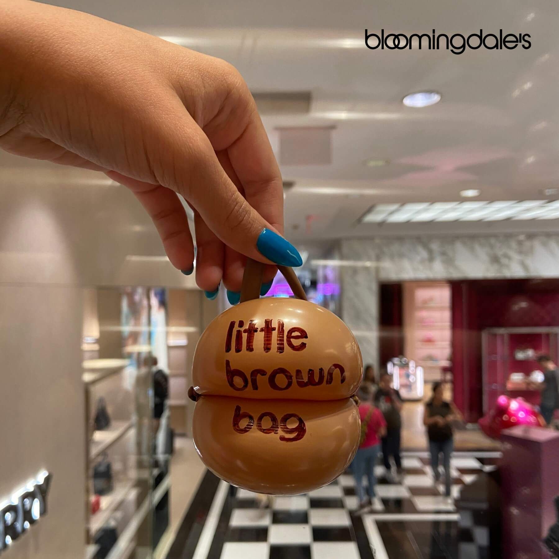 Hand holding a brown Bloomingdale's 