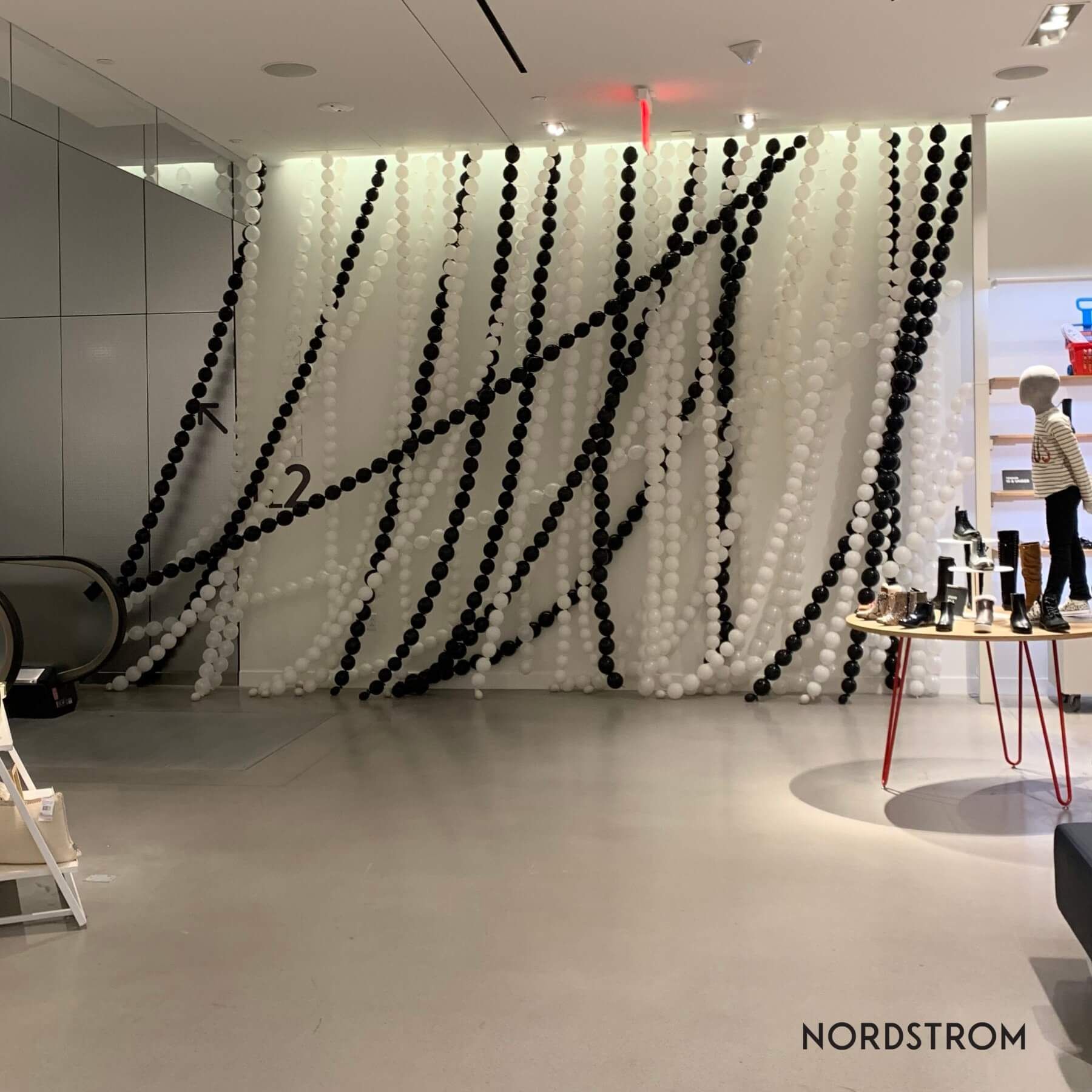 Nordstrom display with black and white decorative chains hanging from the ceiling.