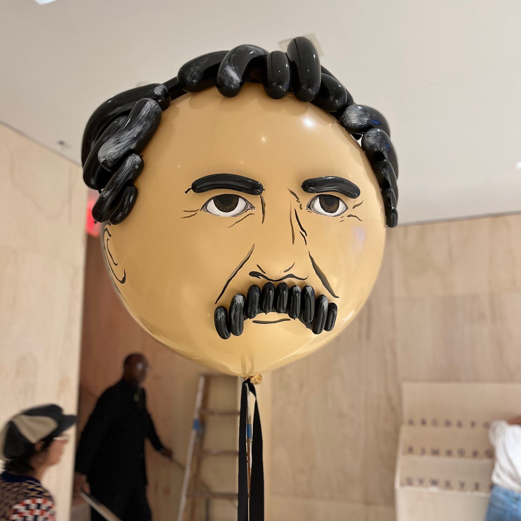 A balloon shaped like Friedrich Nietzsche's face, with black hair and mustache.