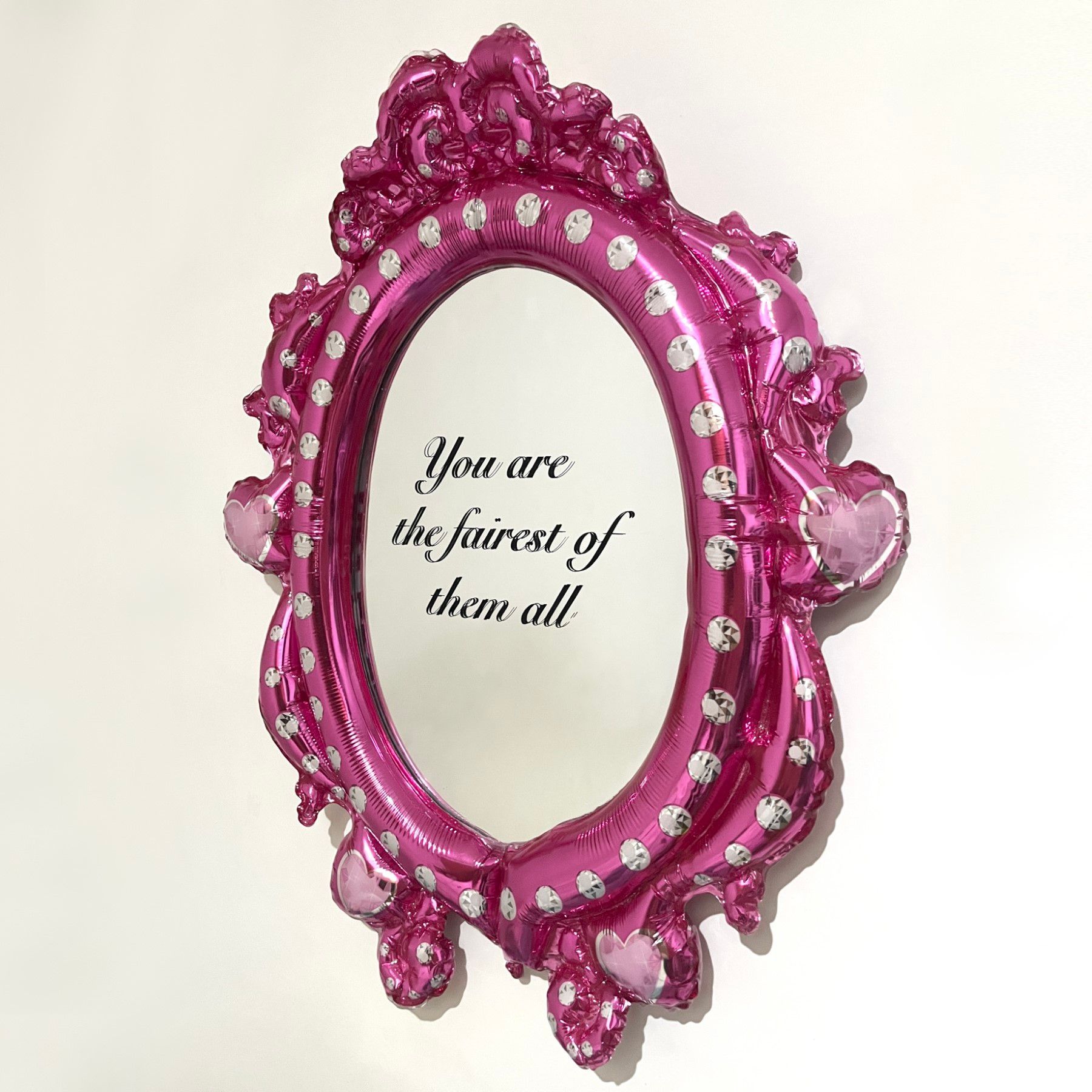 A pink mirror with the words `` you are the fairest of them all '' written on it.
