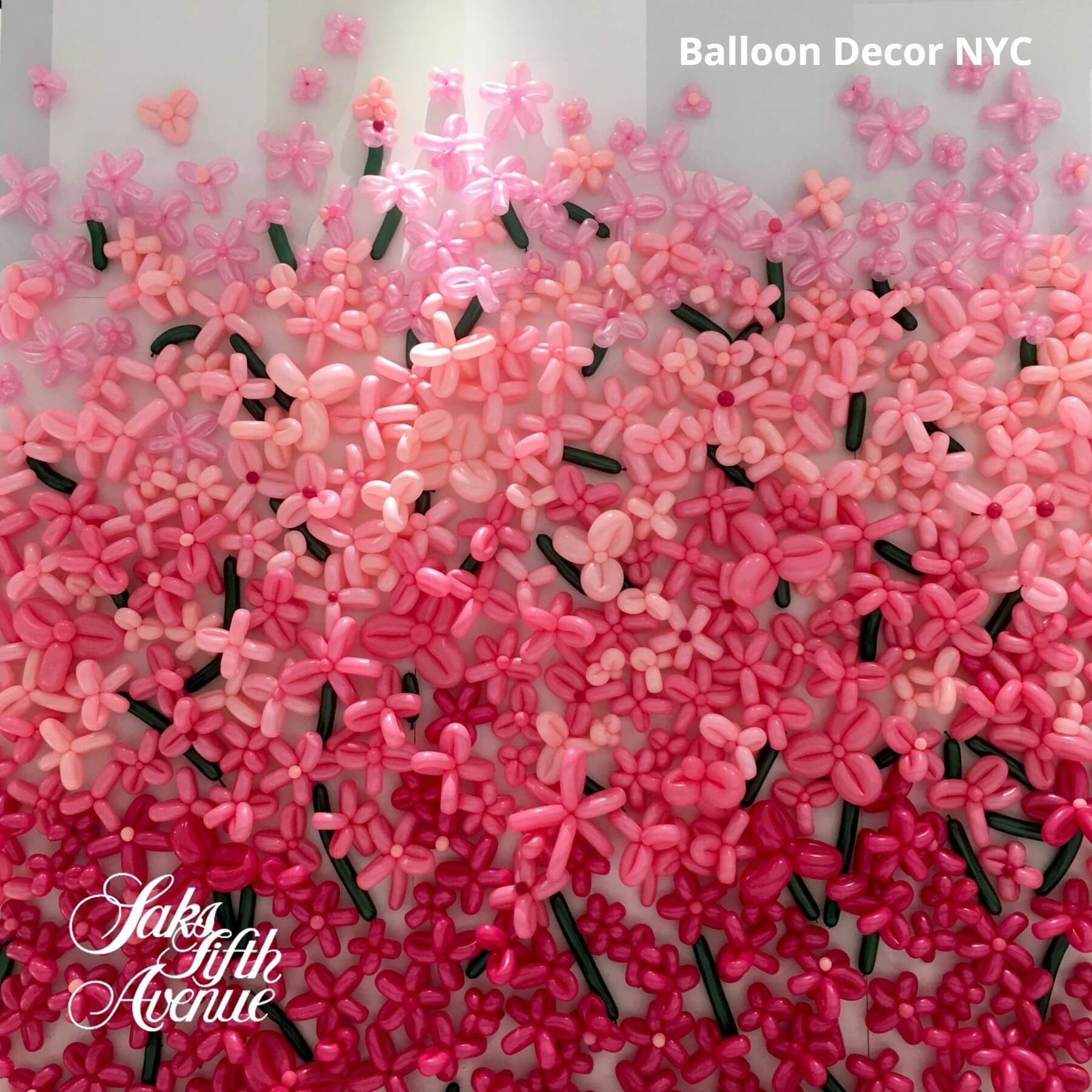 A wall made of pink balloons that look like flowers