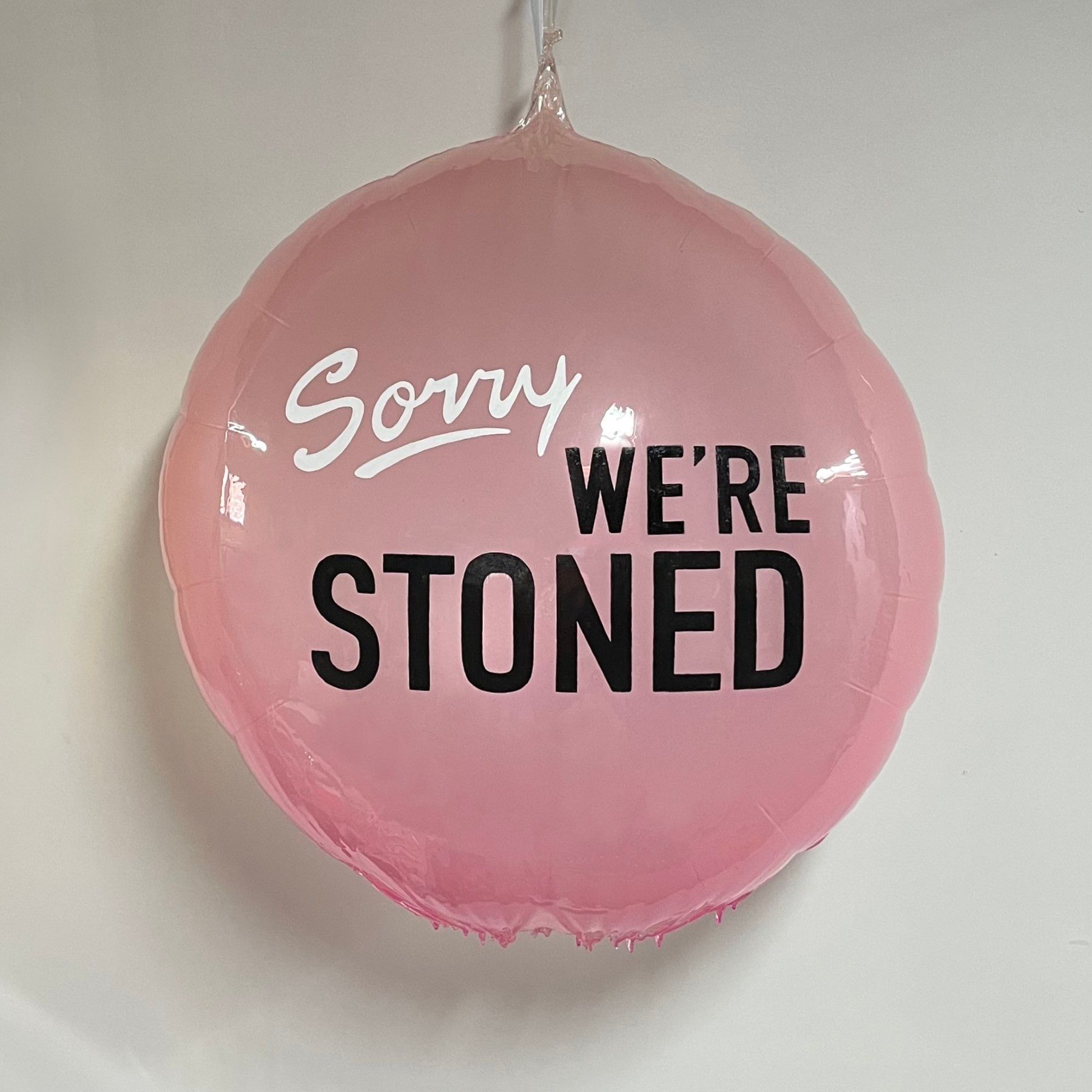 A pink balloon that says sorry we 're stoned