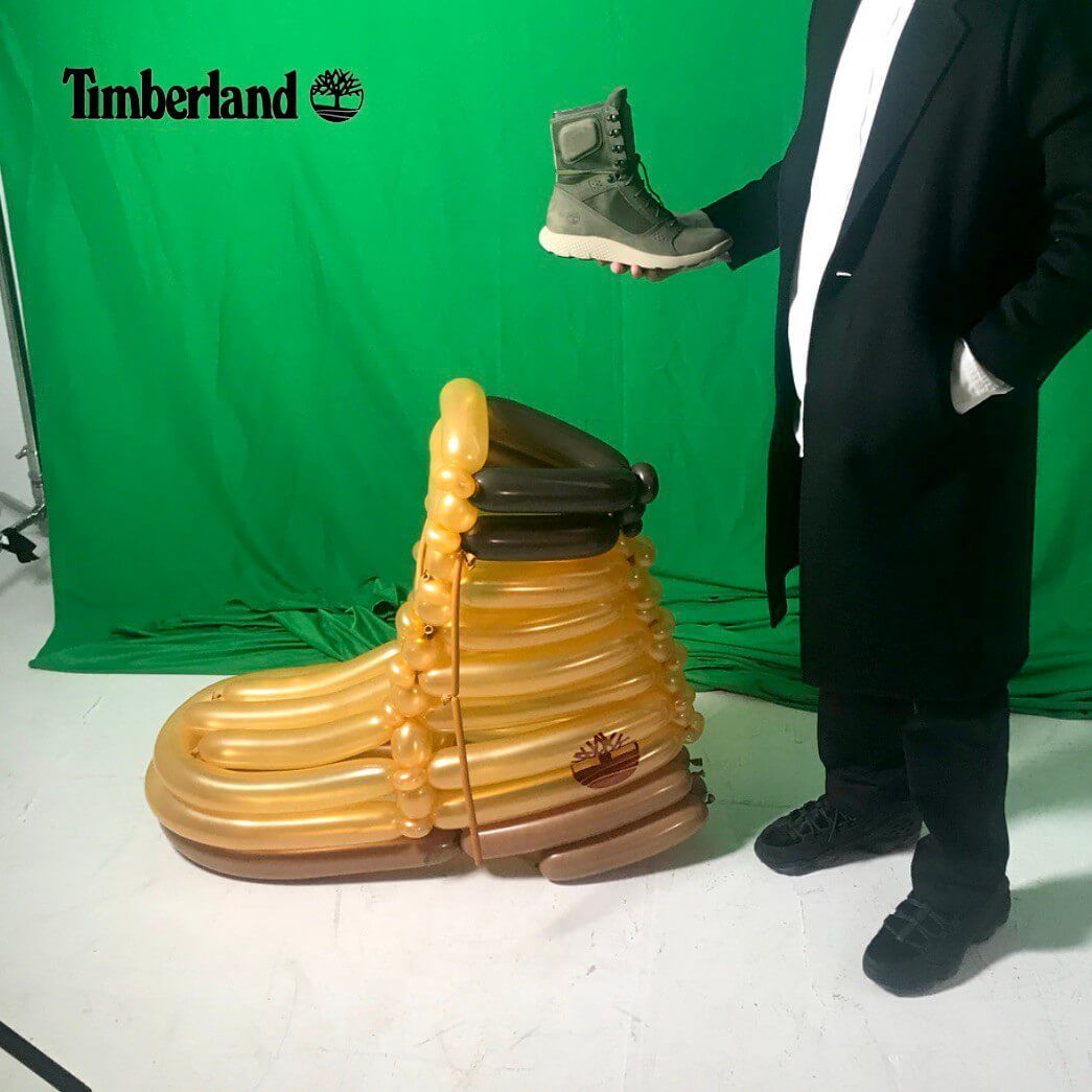 A man is holding a pair of timberland boots