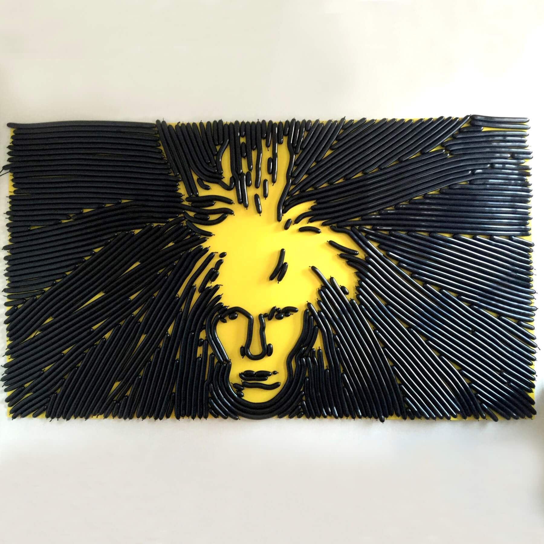 A drawing of a man 's face made out of black straws