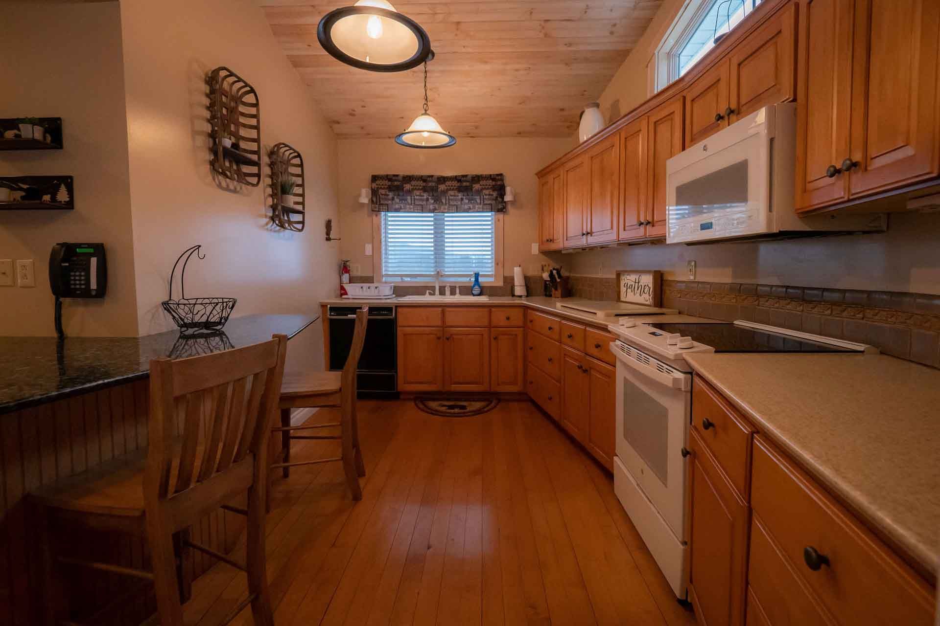 A kitchen with wooden cabinets, a stove, a microwave, and a sink.