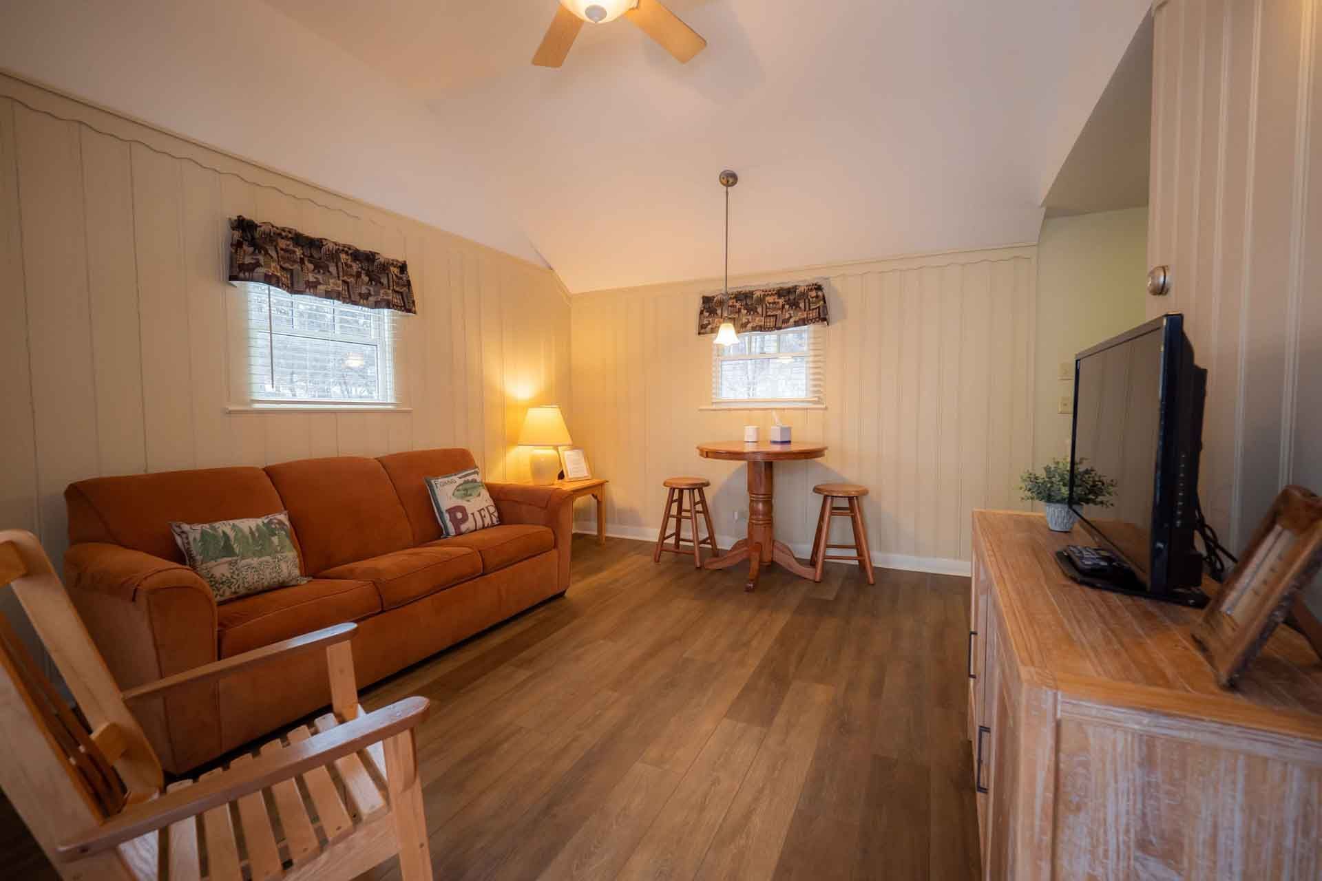 A living room with a couch, chair, table, and television.