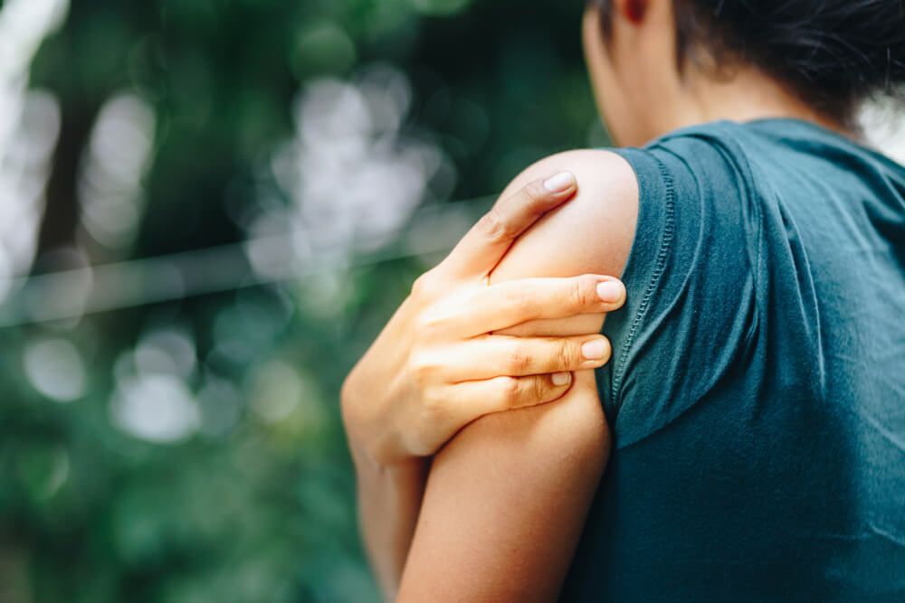  Person holding their painful shoulder.