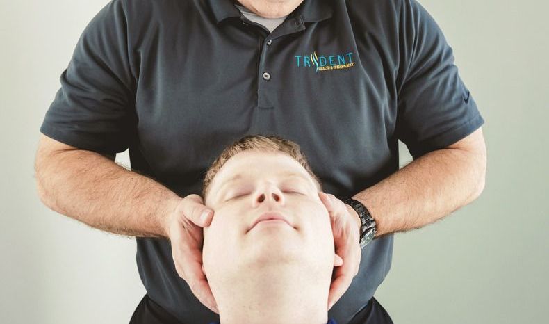 Chiropractor adjusting patient's head.