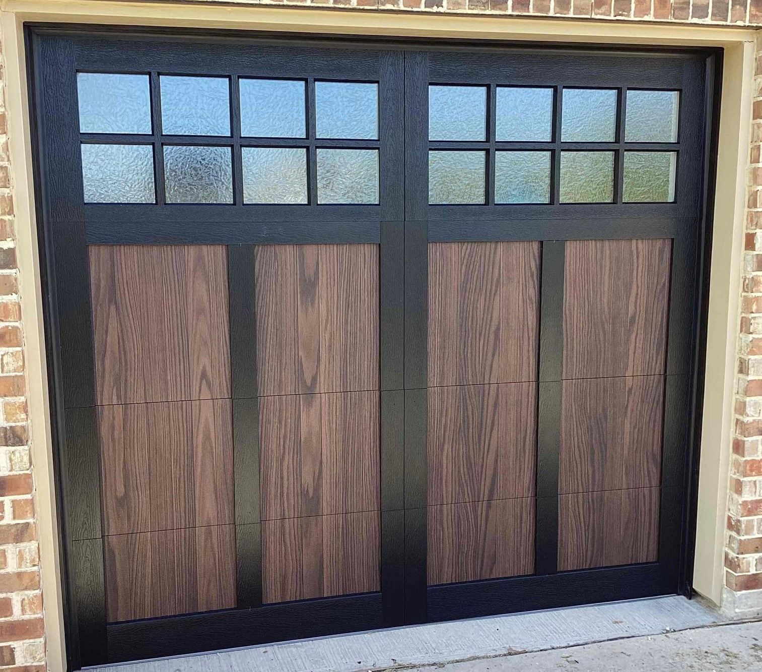 A garage door with a wooden door and a black frame