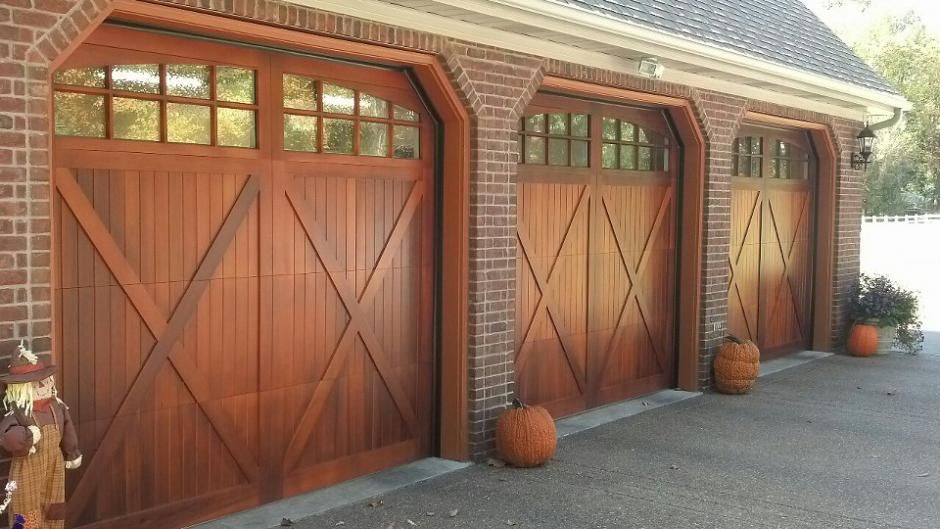 A row of wooden garage doors on a brick building