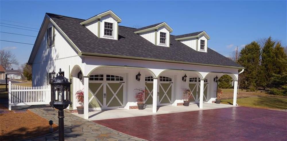 A white house with three garage doors and a porch