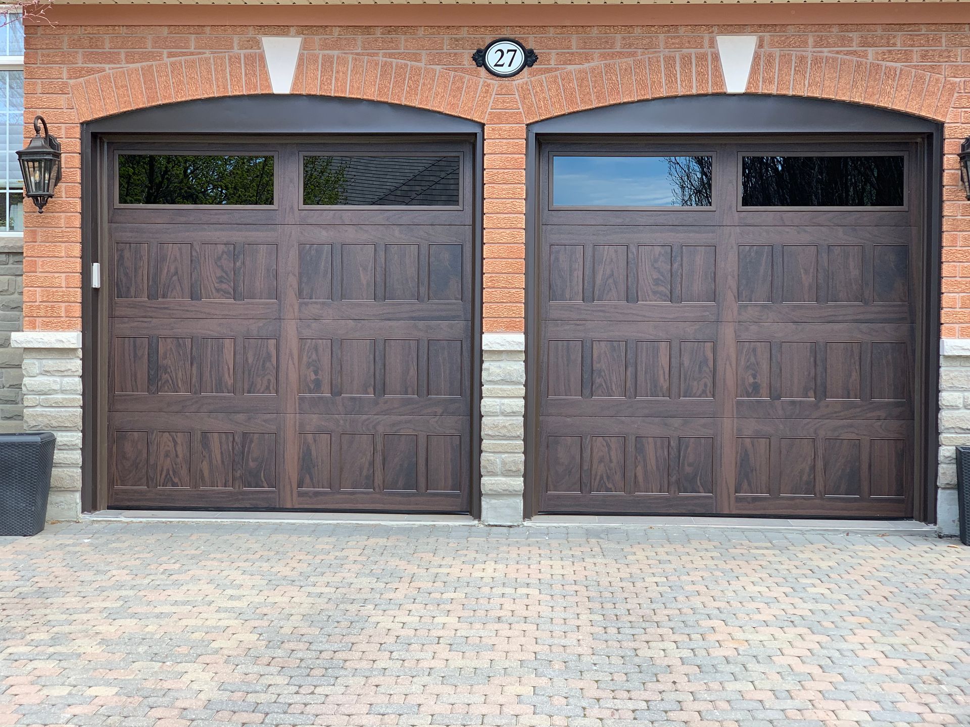 A pair of garage doors are sitting in front of a brick building.