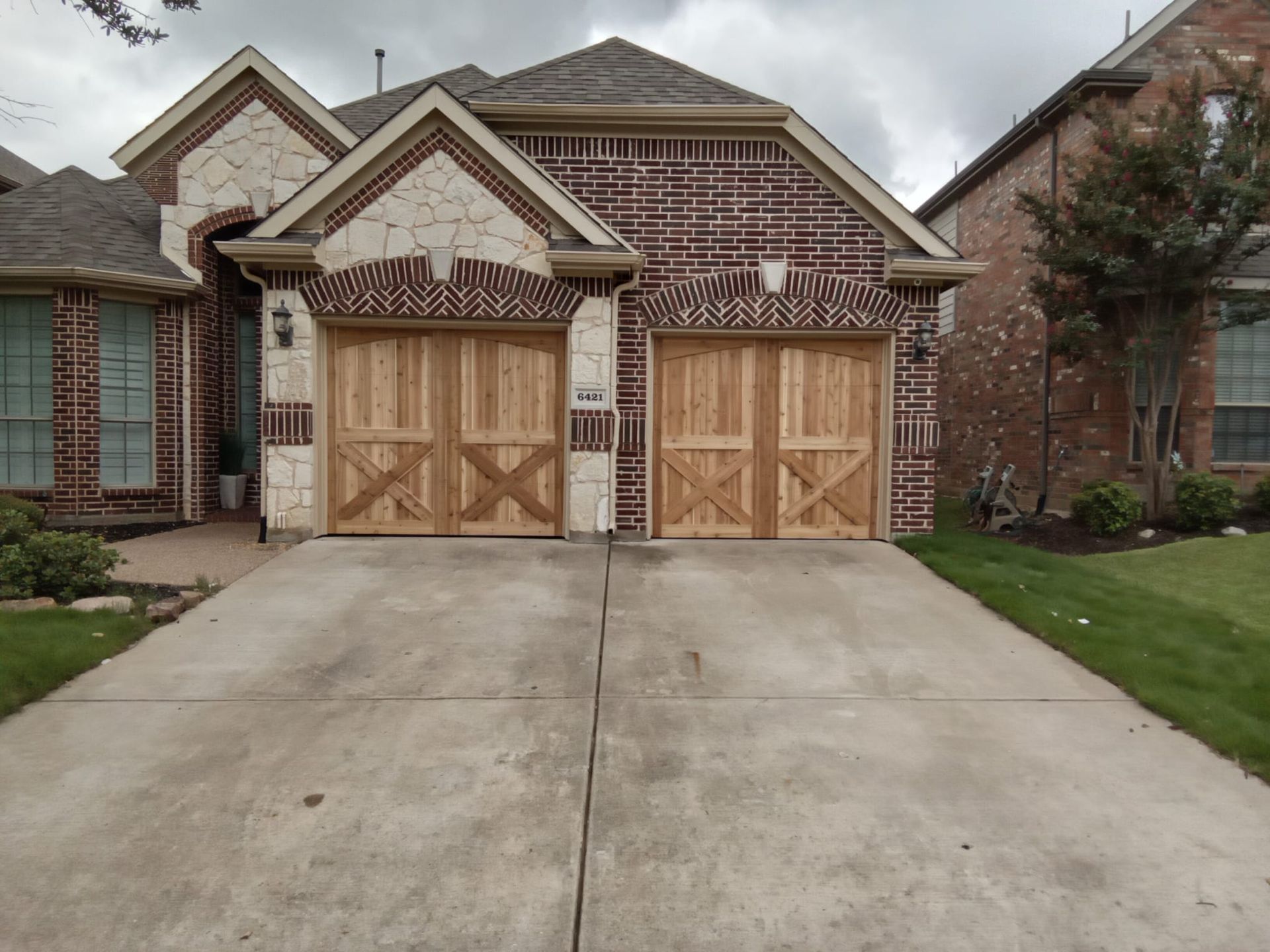 A brick house with two wooden garage doors