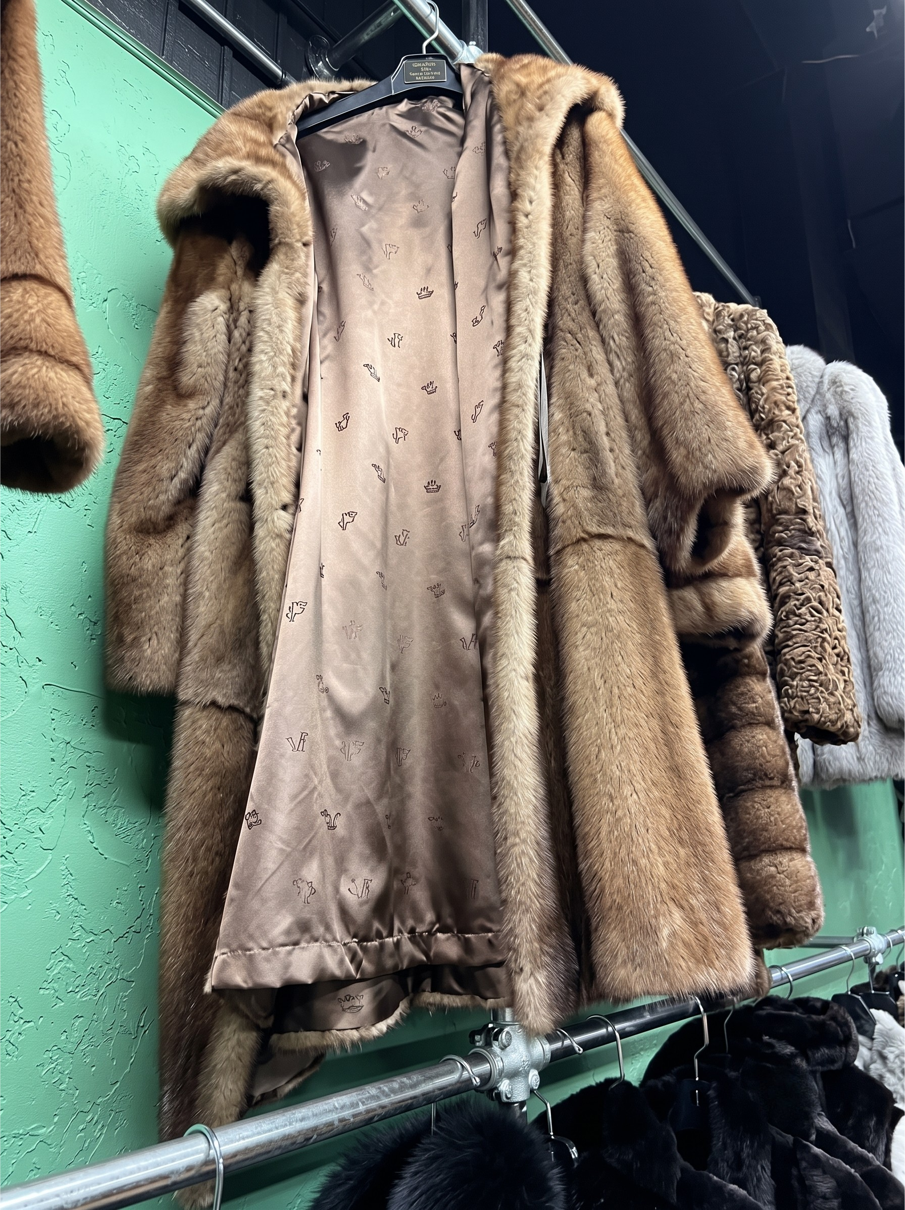 Custom designed brown fur coat with patterned silk lining hanging at USA Furs by George Manhattan