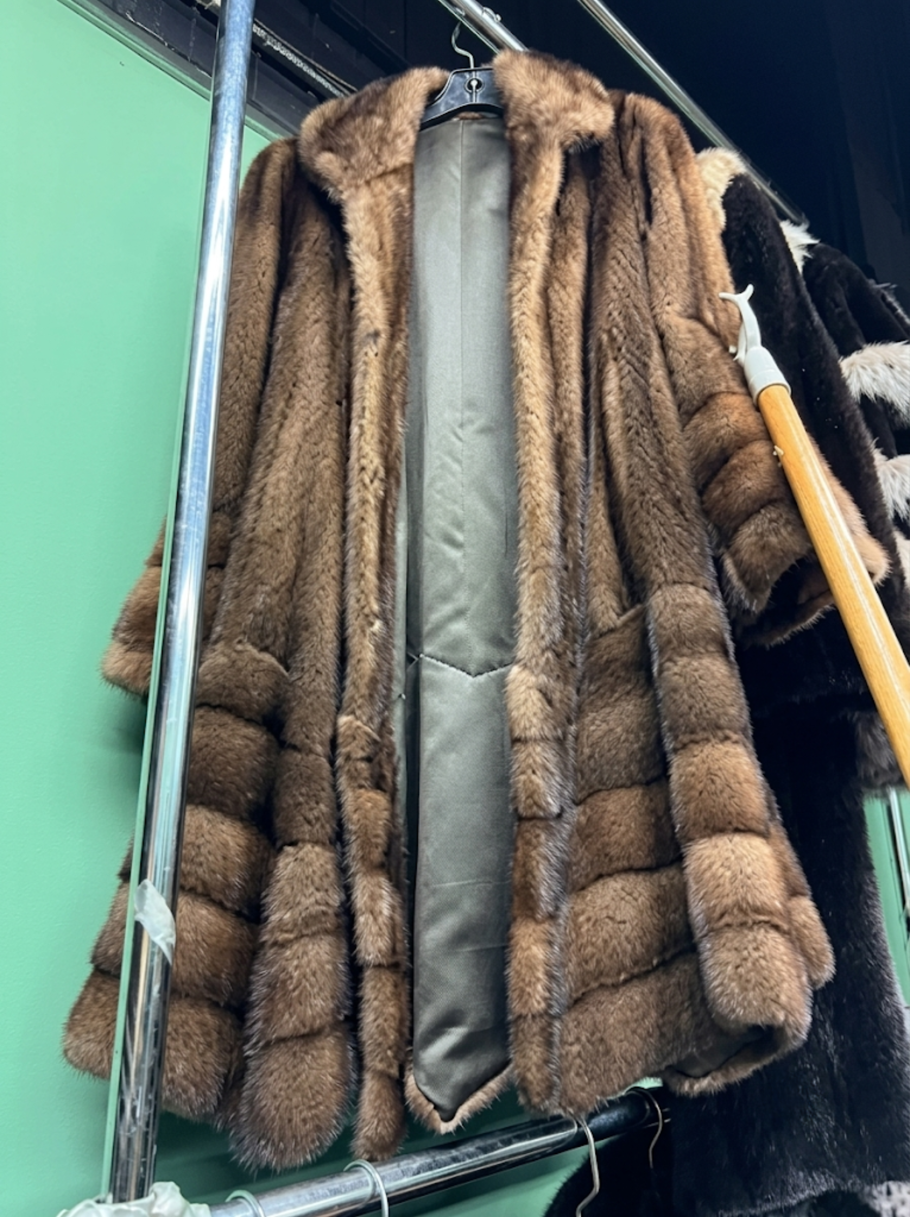 Premium handcrafted brown tiered mink fur coat hanging on rack at USA Furs by George New York