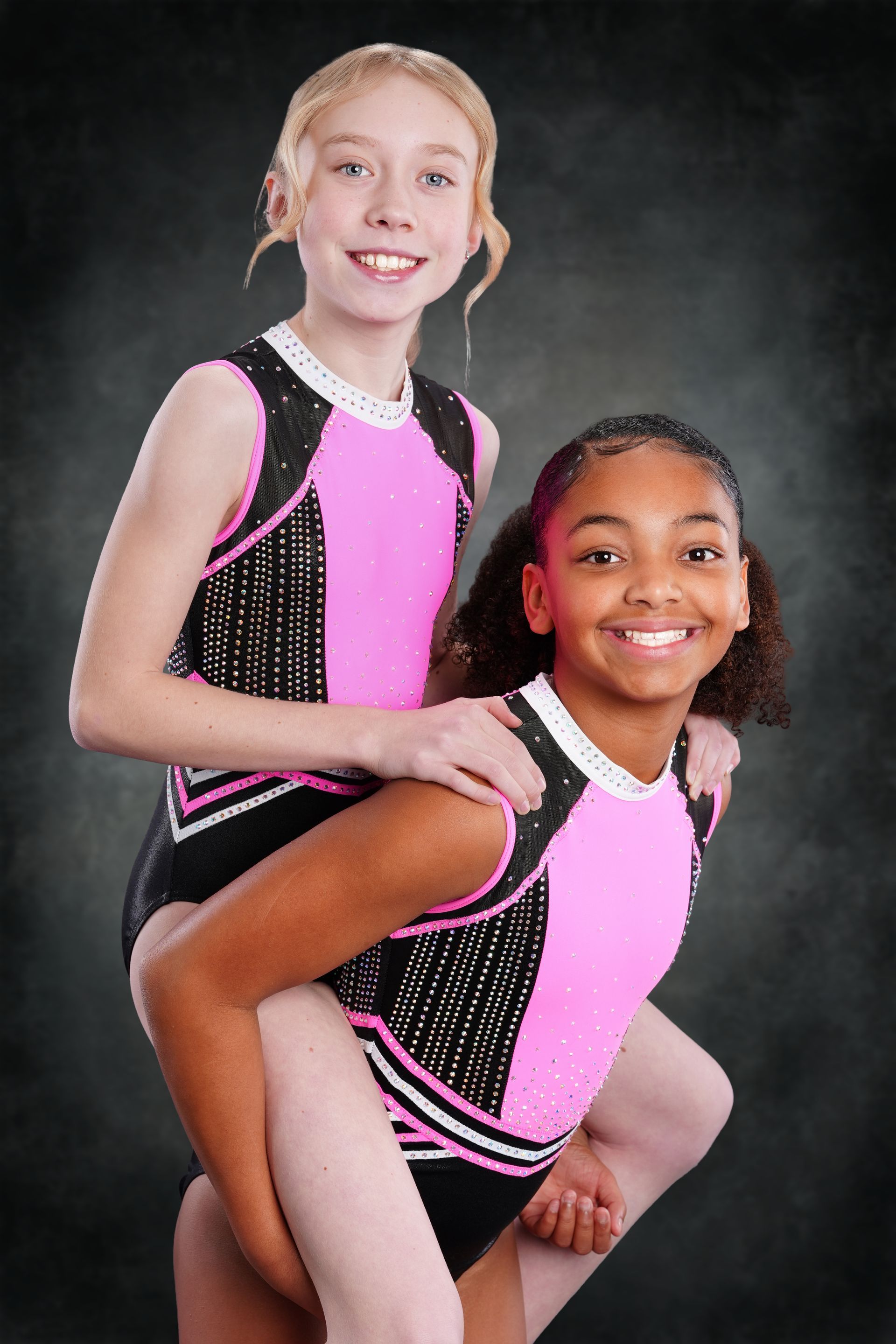A gymnast is sitting on a balance beam covered in chalk.