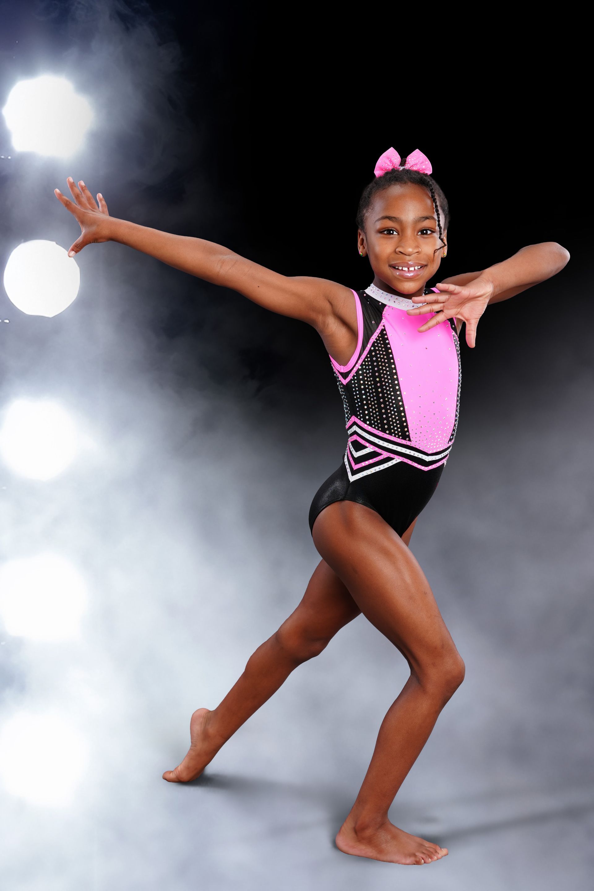 A gymnast is sitting on a balance beam covered in chalk.