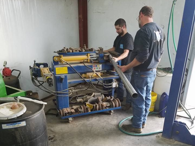 Technicians Working With Automotive Equipment In Shop | Carthage Service Center and Tires