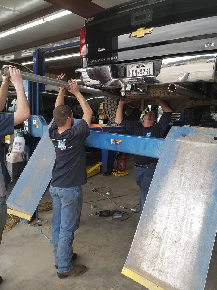 Technician Working Under Lifted Chevrolet Truck | Carthage Service Center and Tires