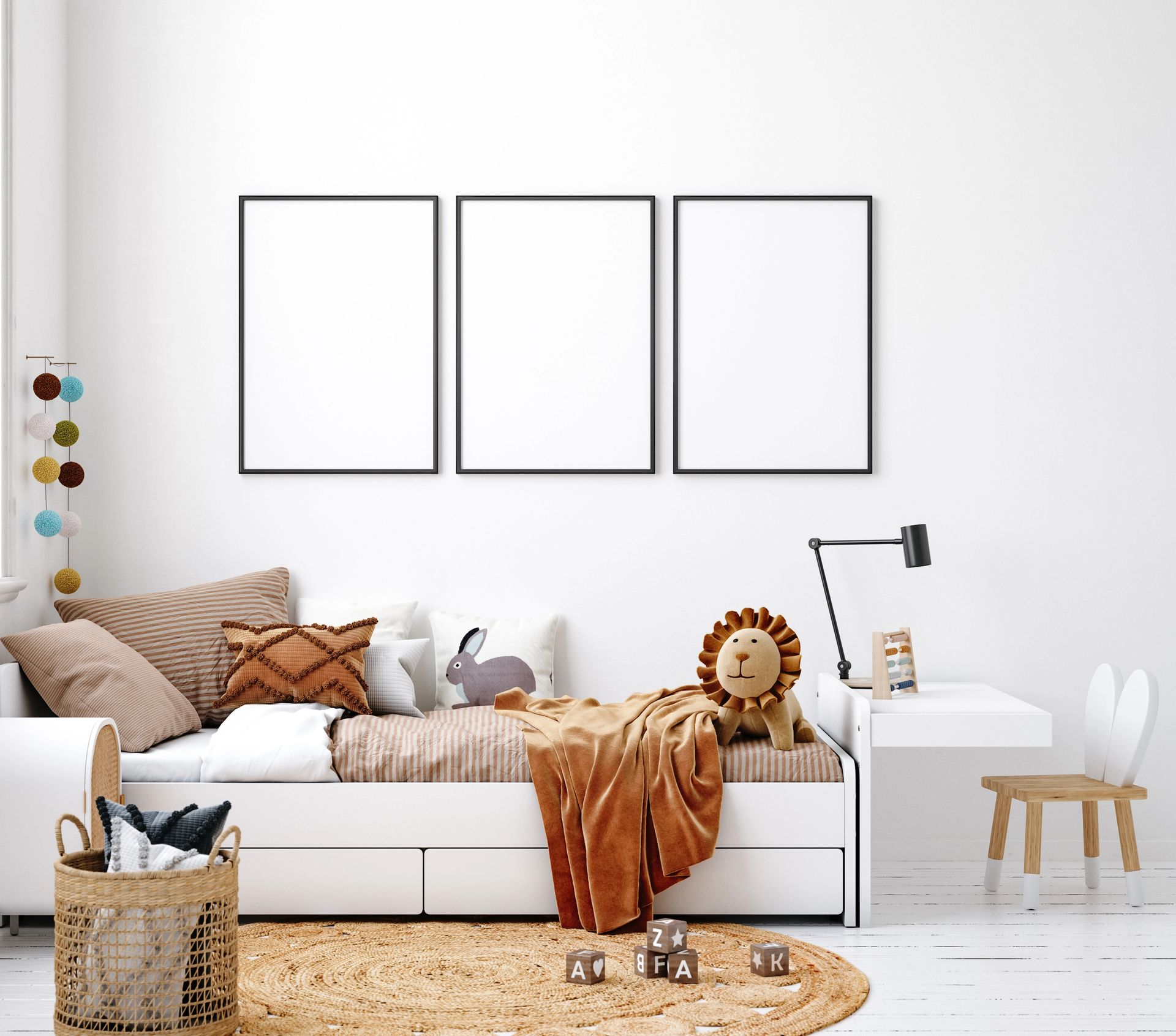Camera da letto bianca minimalista con un divano letto, un tappeto intrecciato e tre quadri vuoti incorniciati a parete