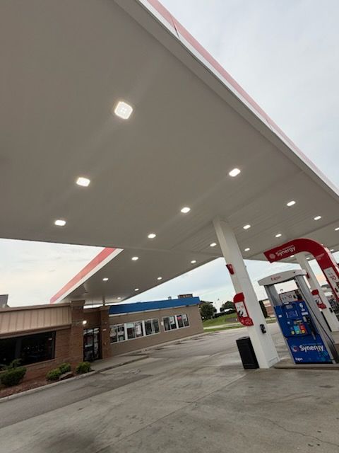 Gas station canopy with pumps and convenience store at dusk