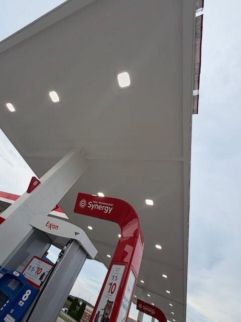 Gas station canopy with bright lights and red Synergy fuel pump signs