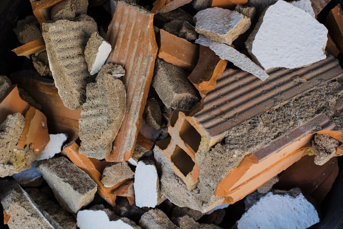A pile of bricks and concrete in a black bucket.